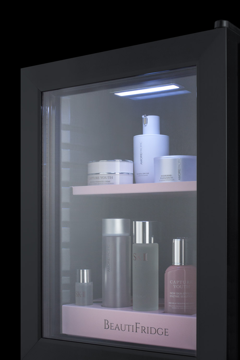 BeautiFridge compact cosmetics cooler with glass door, black cabinet, lock, matte blush pink shelves, and digital controls set for the storage of beauty products